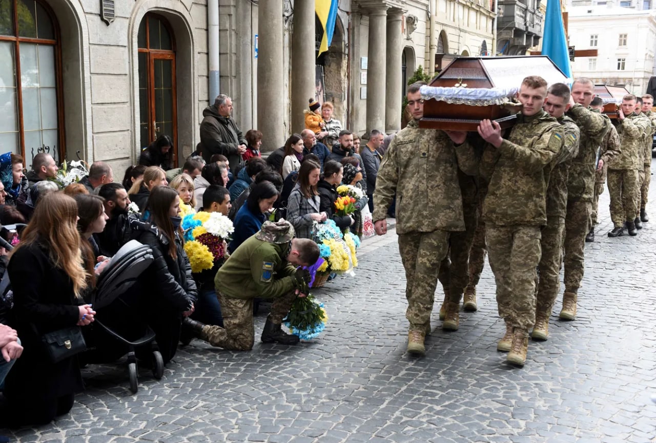 Ukrainalik askarlar jangda halok bo‘lgan quroldoshlarining tobutini ko‘tarib ketmoqda.