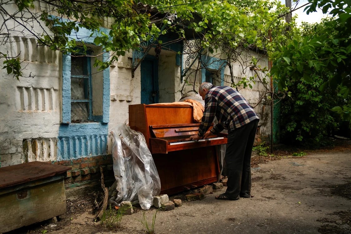 Ukrainadagi Velika Kostromka qishlog‘idagi rus snaryadlaridan keyin zarar ko‘rgan uy oldida pianino chalayotgan Anatoliy Virko.
