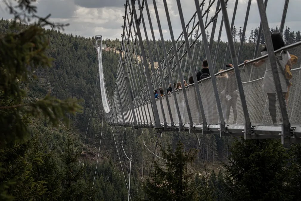 Чехиянинг Пардубице минтақасида узунлиги 721 метр, ердан баландлиги 95 метр бўлган дунёдаги энг узун осма пиёдалар кўприги – Sky Bridge 721 орқали ўтишаётган одамлар.