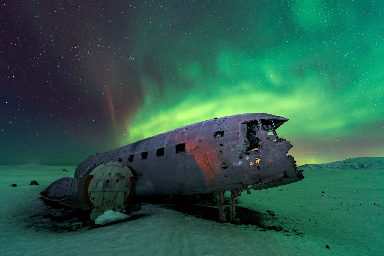 Исландияда фотосуратчи самолёт қолдиқларини шимол ёғдуси фонида суратга олди.