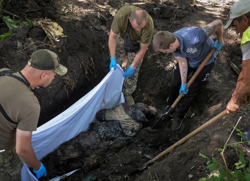 Ukraina Qurolli kuchlari ko‘ngillilari va xodimlari bir necha oy oldin Xarkovda dafn etilgan rossiyalik askarning jasadini eksgumatsiya qilmoqda.