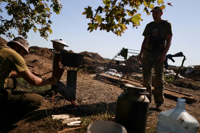 Ukrainalik harbiy Xarkov yaqinidagi marralarda ovqat pishirmoqda