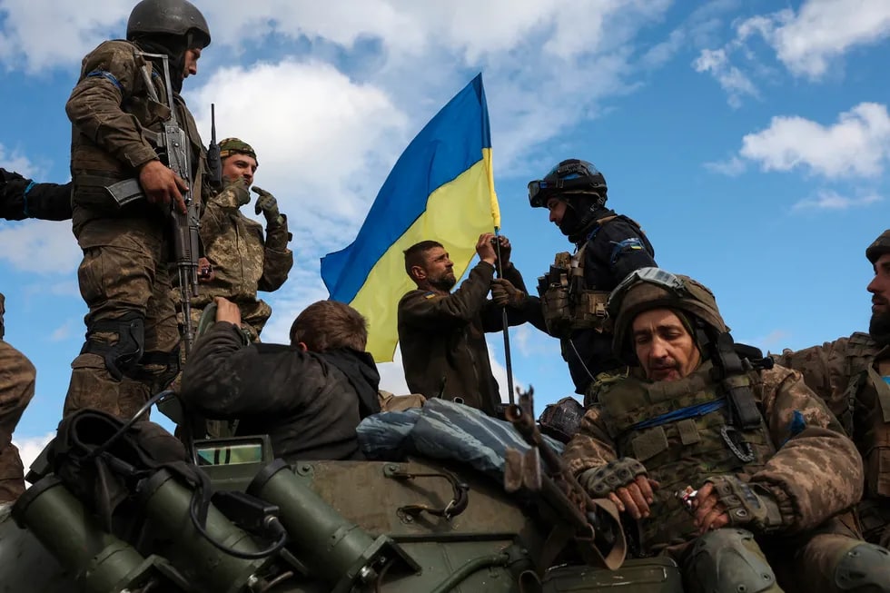 Ukraina harbiylari Donetsk viloyati Liman yaqinidagi yo‘lda bronotransportyorga davlat bayrog‘ini o‘rnatmoqda.