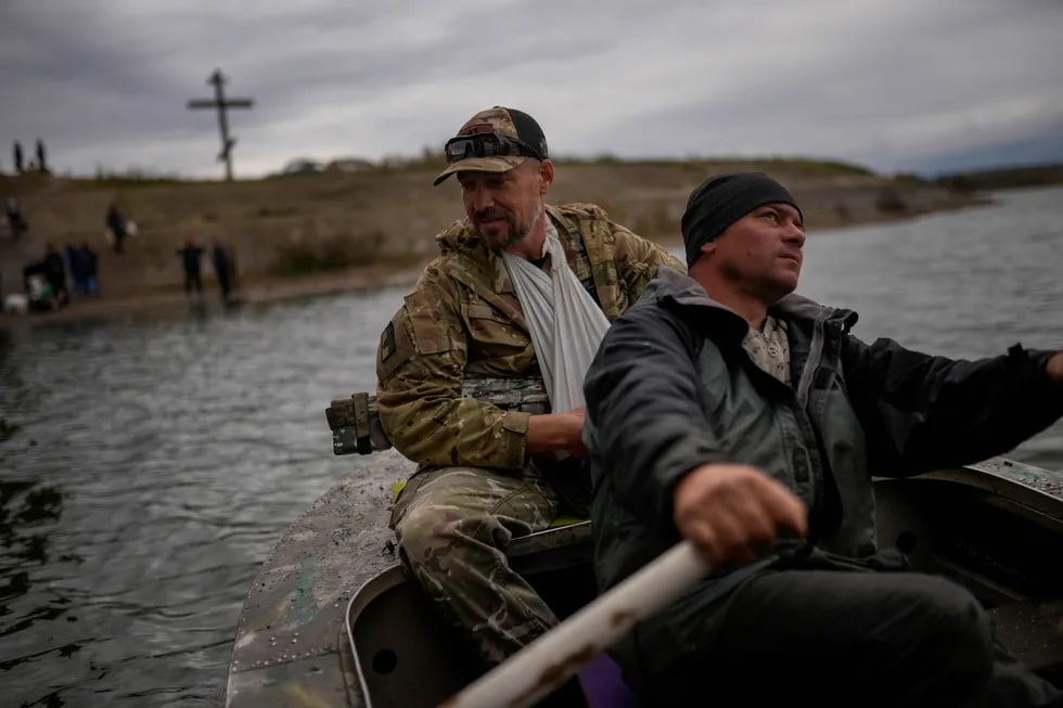 Юрий Шаповалов яраланган украиналик аскарни Старий Салтовдаги дарёдан ўтказиб қўймоқда. Харьковдан 45 километр шарқда жойлашган қишлоқ май ойи бошида озод қилинган эди.