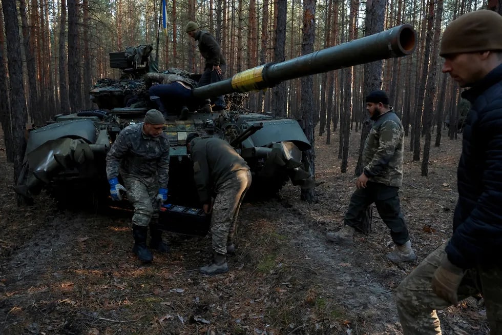 Ukrainalik harbiylar Rossiya tankidan akkumlyatorini olib, zaryad qilish uchun olib ketmoqda.