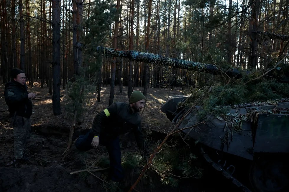 Ukraina harbiylari qo‘lga olingan rus tankini o‘rmonda shoxlar bilan bekitmoqda.