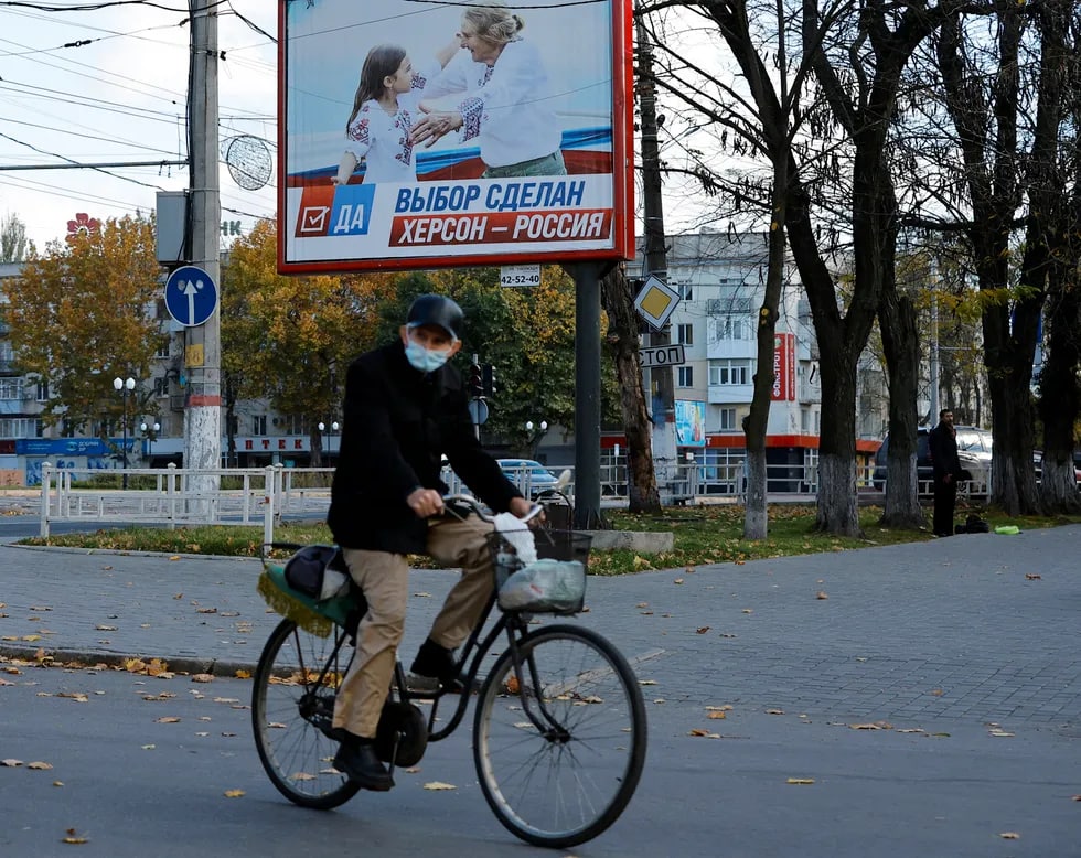 “Vibor sdelan. Xerson — Rossiya“ (Tanlov qilindi. Xerson — Rossiya) shiori aks etgan bilbord fonidagi velosipedchi. Sentabr oyi oxirida Xerson viloyatining bosib olingan qismida, shuningdek Zaporojye viloyatining rossiyaliklar tomonidan egallangan qismida hamda Donetsk va Lugansk xalq respublikalarida Rossiya tarkibiga qo‘shilish bo‘yicha referendumlar o‘tkazilgandi. Rossiya tomonidan tayinlangan ma’muriyatga ko‘ra, Xerson viloyatida ovoz berganlarning 87,05 foizi Rossiya tarkibiga qo‘shilishni ma’qullagan.