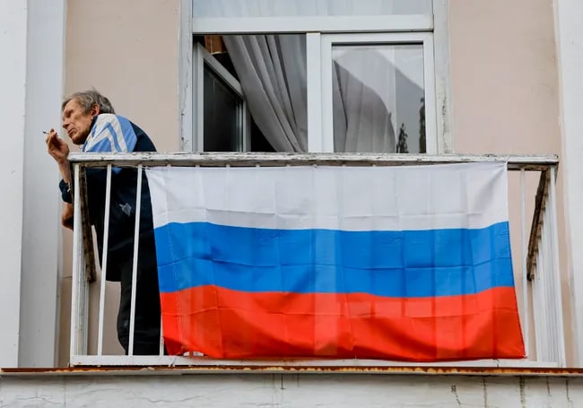 Donetskda balkoniga Rossiya bayrog‘i ilingan aholi vakili.