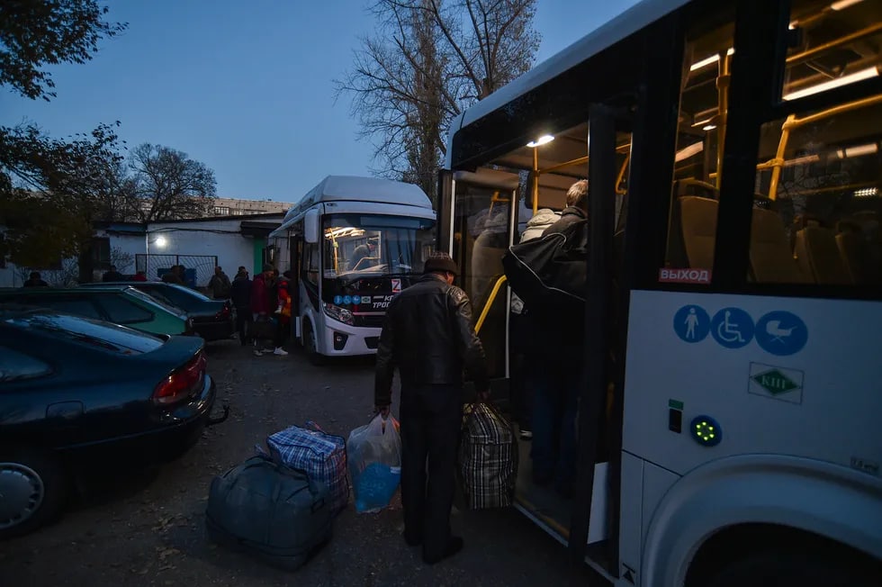 Херсон вилояти аҳолиси Жанкойдаги вақтинчалик турар жой маркази яқинидаги автобусларда.