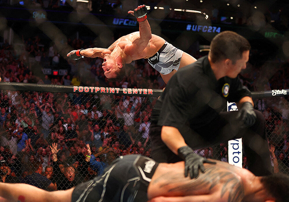UFC yulduzlari o‘rtasida kechgan jangda Toni Fergyusonni dahshatli nokautga uchratgan Maykl Chendler salto namoyish qilmoqda.