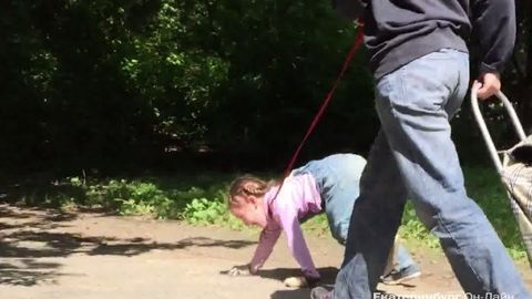 Rossiyalik ayol yosh qizchani it tasmasi bilan bog‘lab, sayr qildirdi (video)