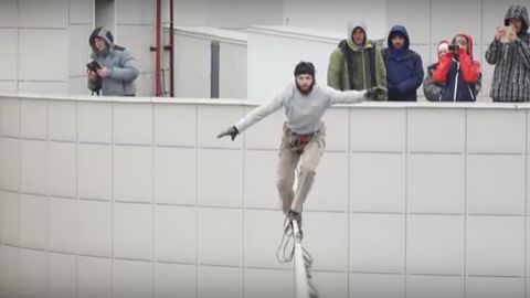Россияда экстремал 16 қаватли уйлар орасига тортилган осма арқондан юриб ўтди (видео)