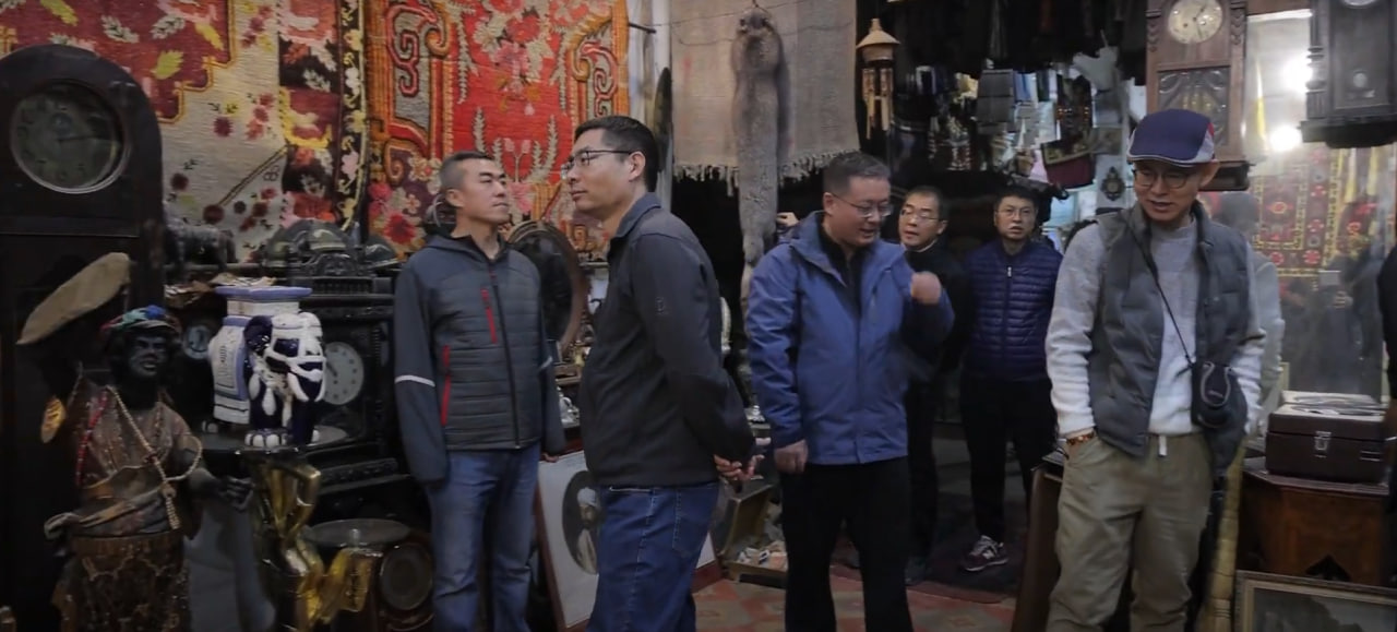 A group of Chinese shoppers examine exhibits with historical value, Yangiabad Bazaar, Tashkent, Uzbekistan, November 2024  Photo: Daryo