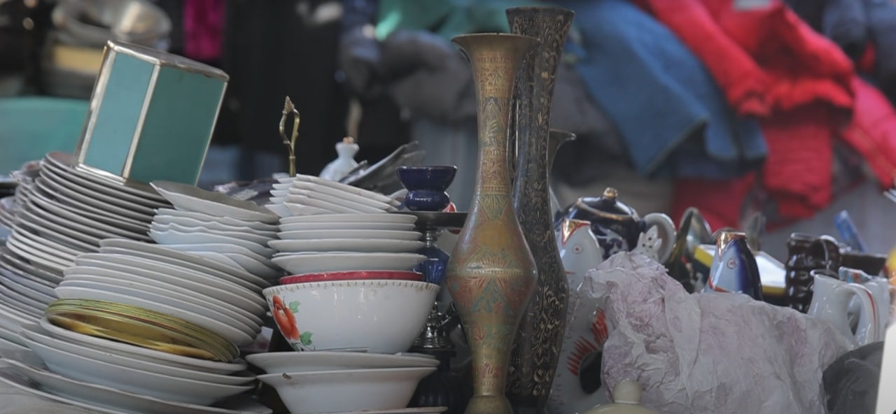 An Indian bronze vase on a bench with traditional Uzbek ceramics and household items, Yangiabad Bazaar, Tashkent, Uzbekistan, November 2024  Photo: Daryo